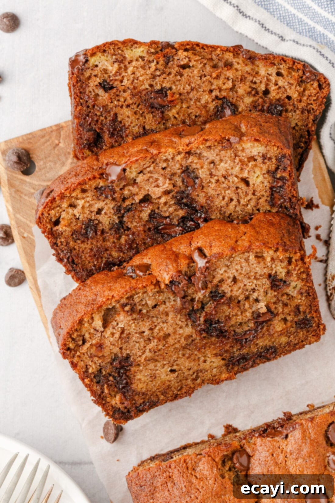 Banana Chip Indulgence 3 Three perfectly sliced pieces of chocolate chip banana bread, showcasing the moist interior and melted chocolate.