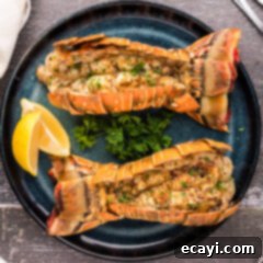 Succulent Grilled Lobster Tail 16 Overhead photo of two Grilled Lobster Tails on a plate with lemons
