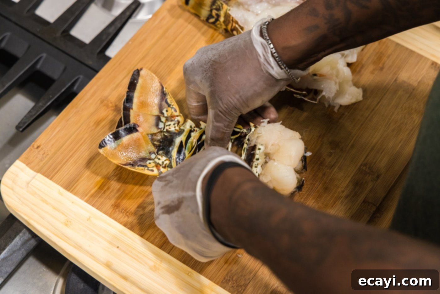 Succulent Grilled Lobster Tail 6 Hands cracking the underbelly of a lobster shell