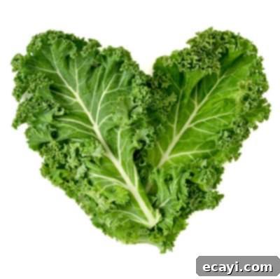 Düşük Karbonhidratlı Sebzeler: Ne Yenmeli, Nelerden Kaçınmalı 5 Fresh, dark green kale leaves arranged in a heart shape, symbolizing its health benefits.