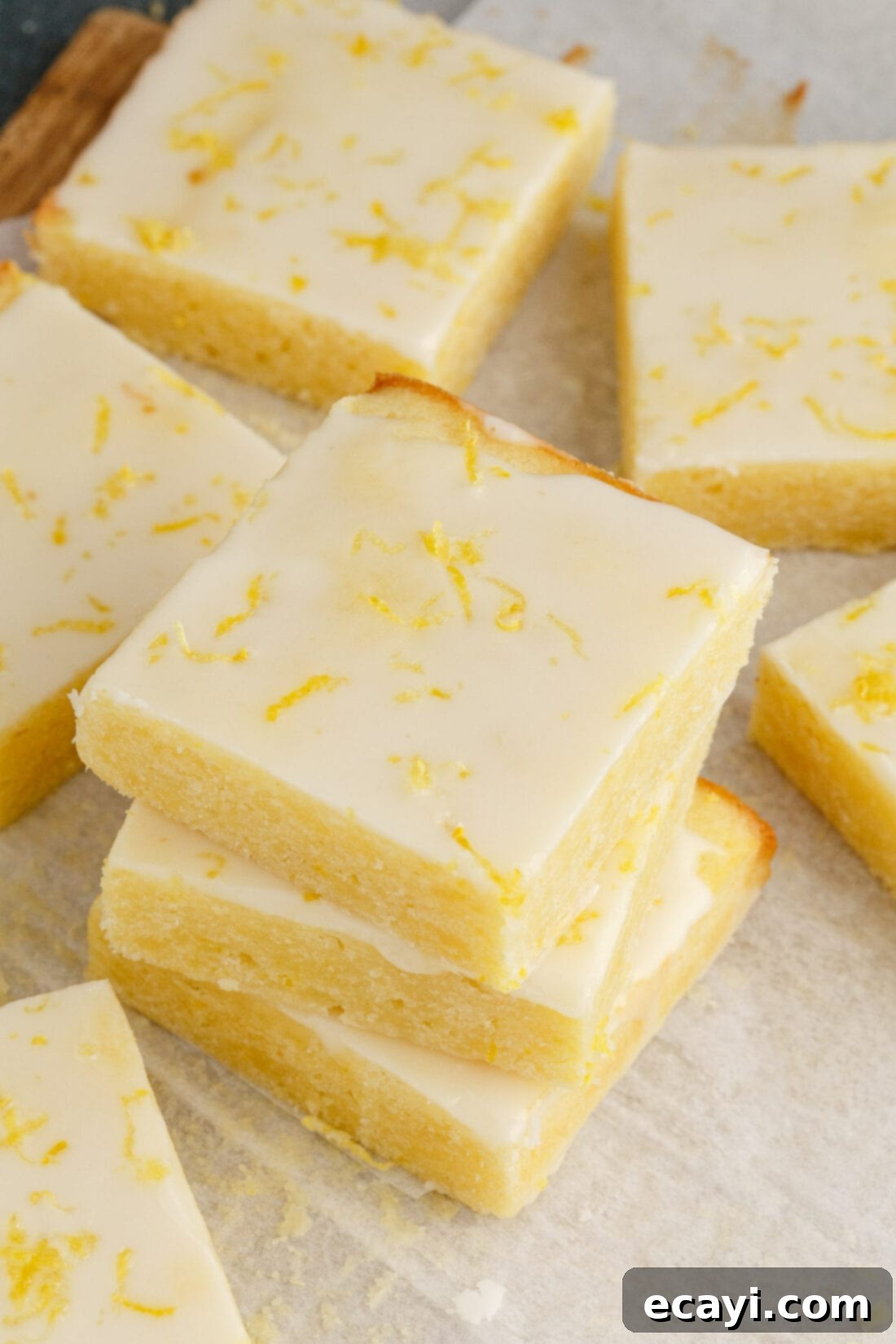 Sunshine Lemon Brownies 3 Stack of Lemon Brownies with a few individual squares next to it, showing the fudgy texture and glaze