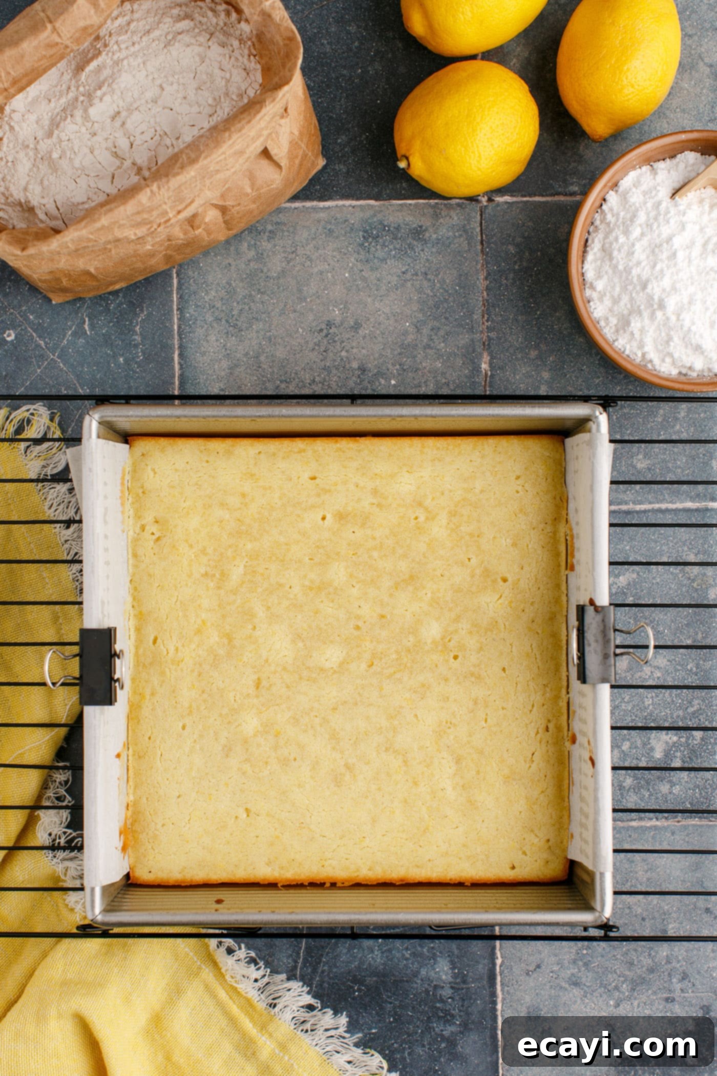 Sunshine Lemon Brownies 9 baked lemon brownies cooling in an 8x8 pan on a wire rack