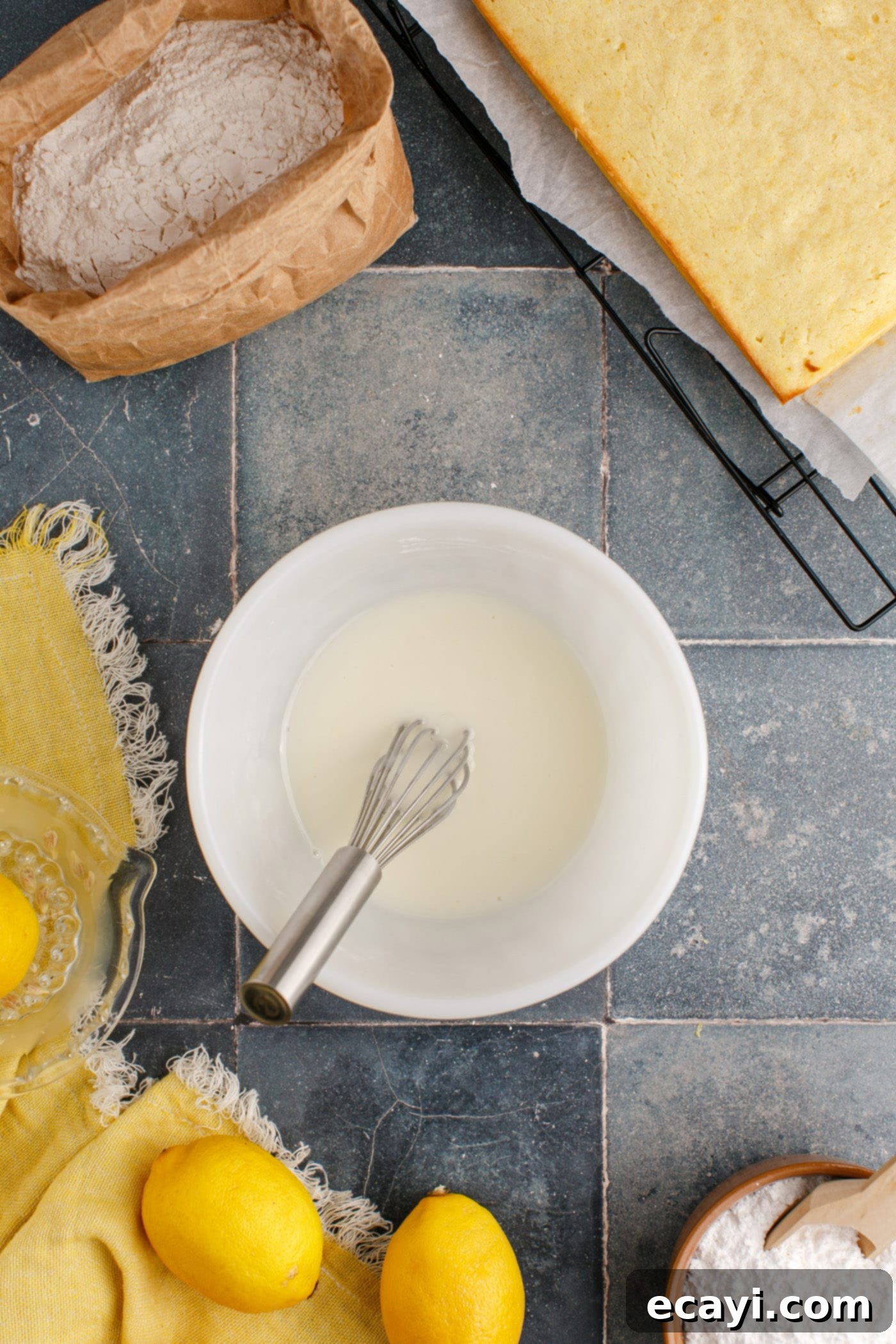 Sunshine Lemon Brownies 10 easy lemon glaze in a small mixing bowl with whisk, showing smooth consistency