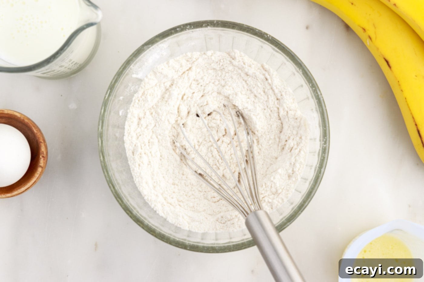 Fluffy Banana Bliss 5 Whisking together the flour, sugar, baking soda, baking powder, salt, and cinnamon in a small bowl