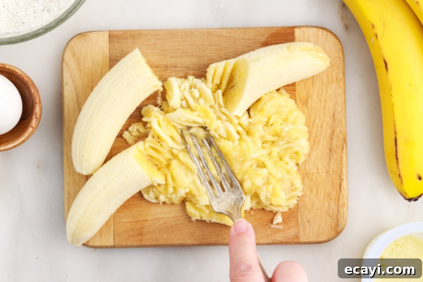 Fluffy Banana Bliss 6 Mashing ripe bananas with a fork in a bowl