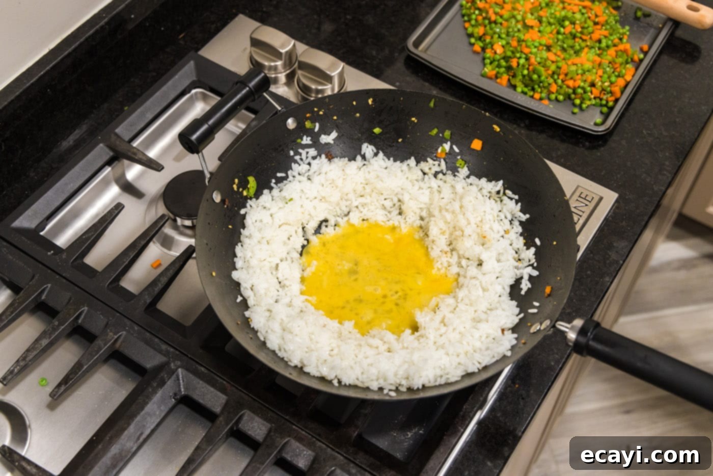Wok-Fired Pork Fried Rice 12 Cooked white rice in a skillet with whisked eggs pooled in a well in the center, before scrambling