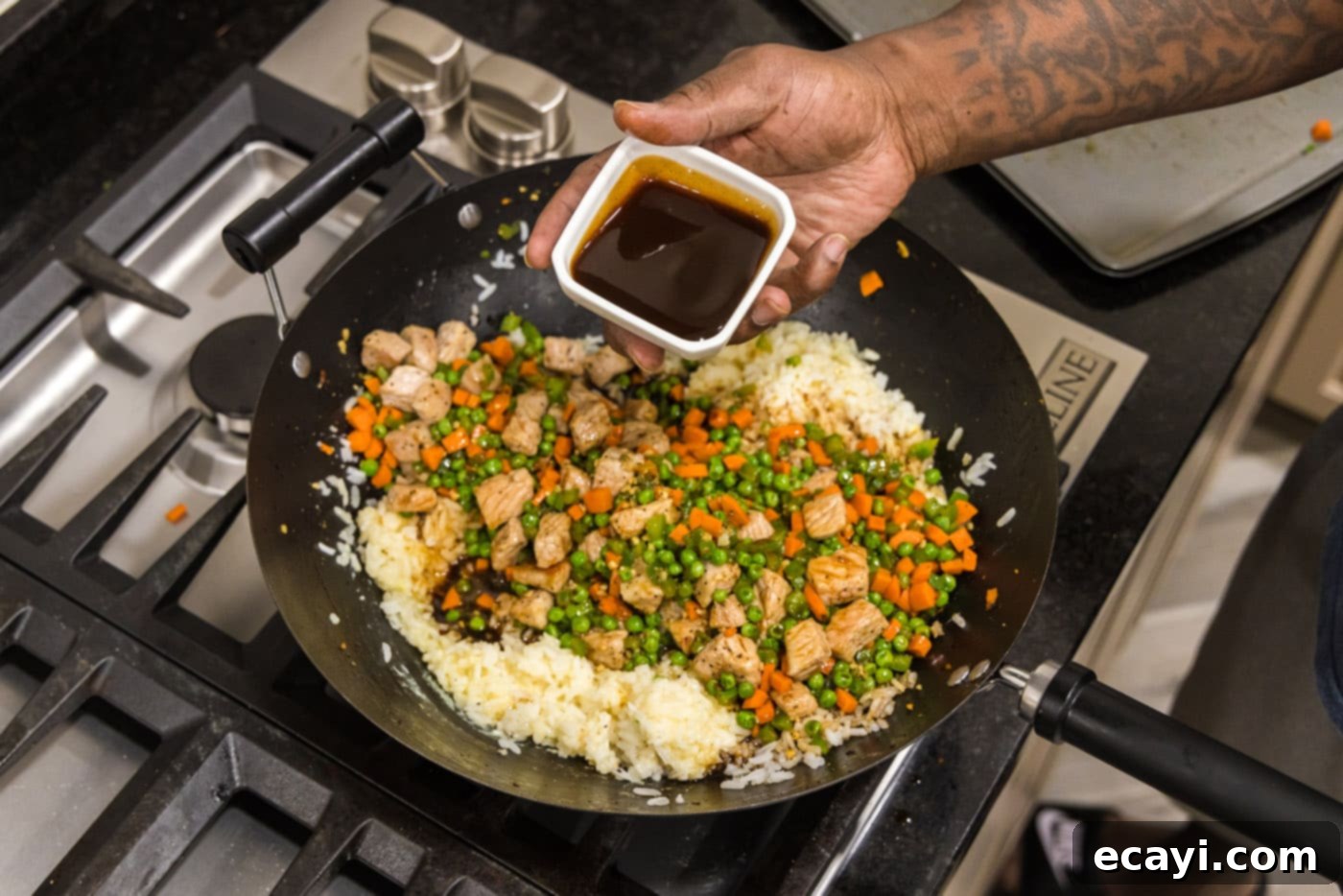 Wok-Fired Pork Fried Rice 15 Adding oyster sauce to the fried rice ingredients in a skillet, creating a rich glaze