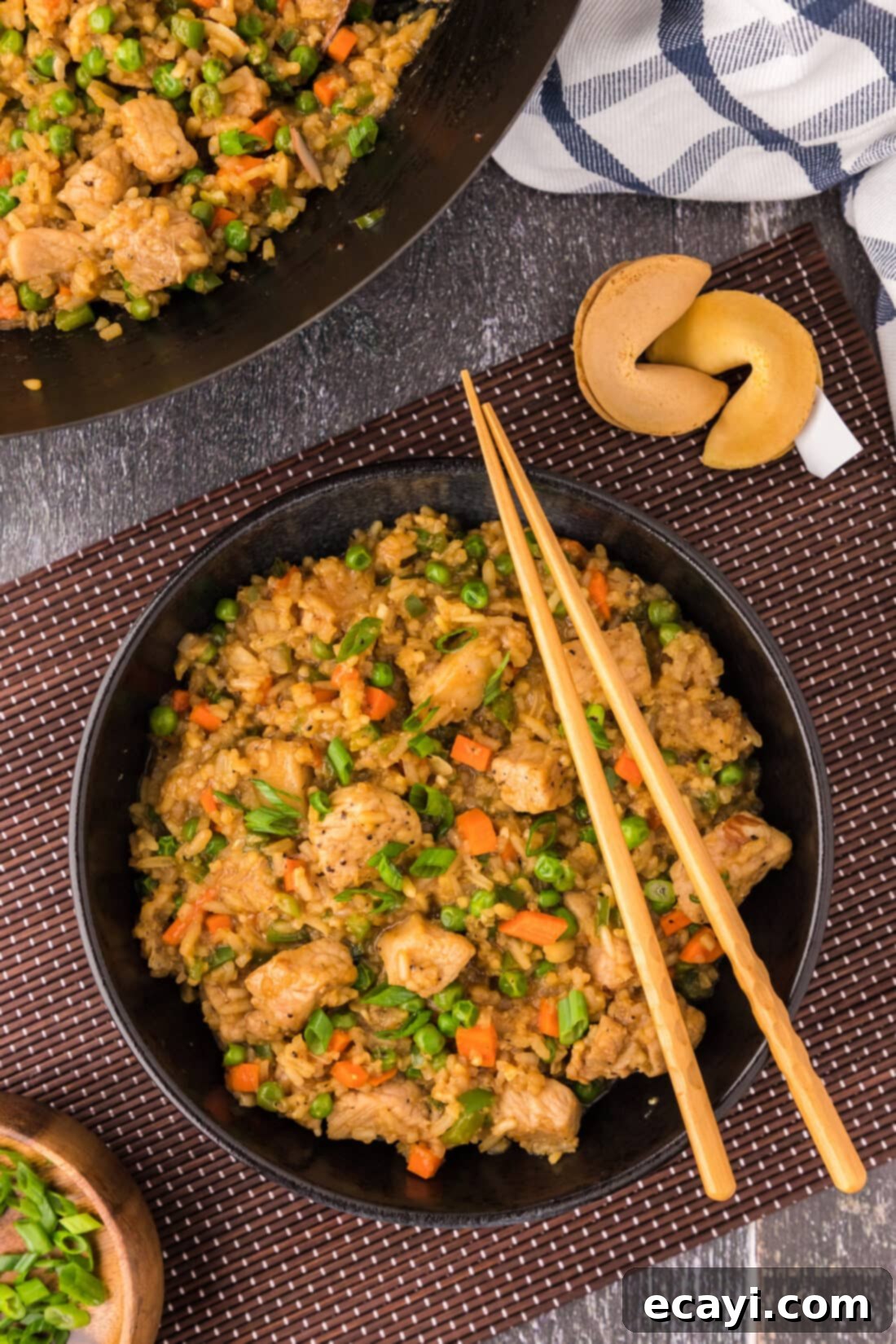 Wok-Fired Pork Fried Rice 3 A serving bowl of homemade Pork Fried Rice with chopsticks resting on the rim, showcasing tender pork pieces and colorful vegetables