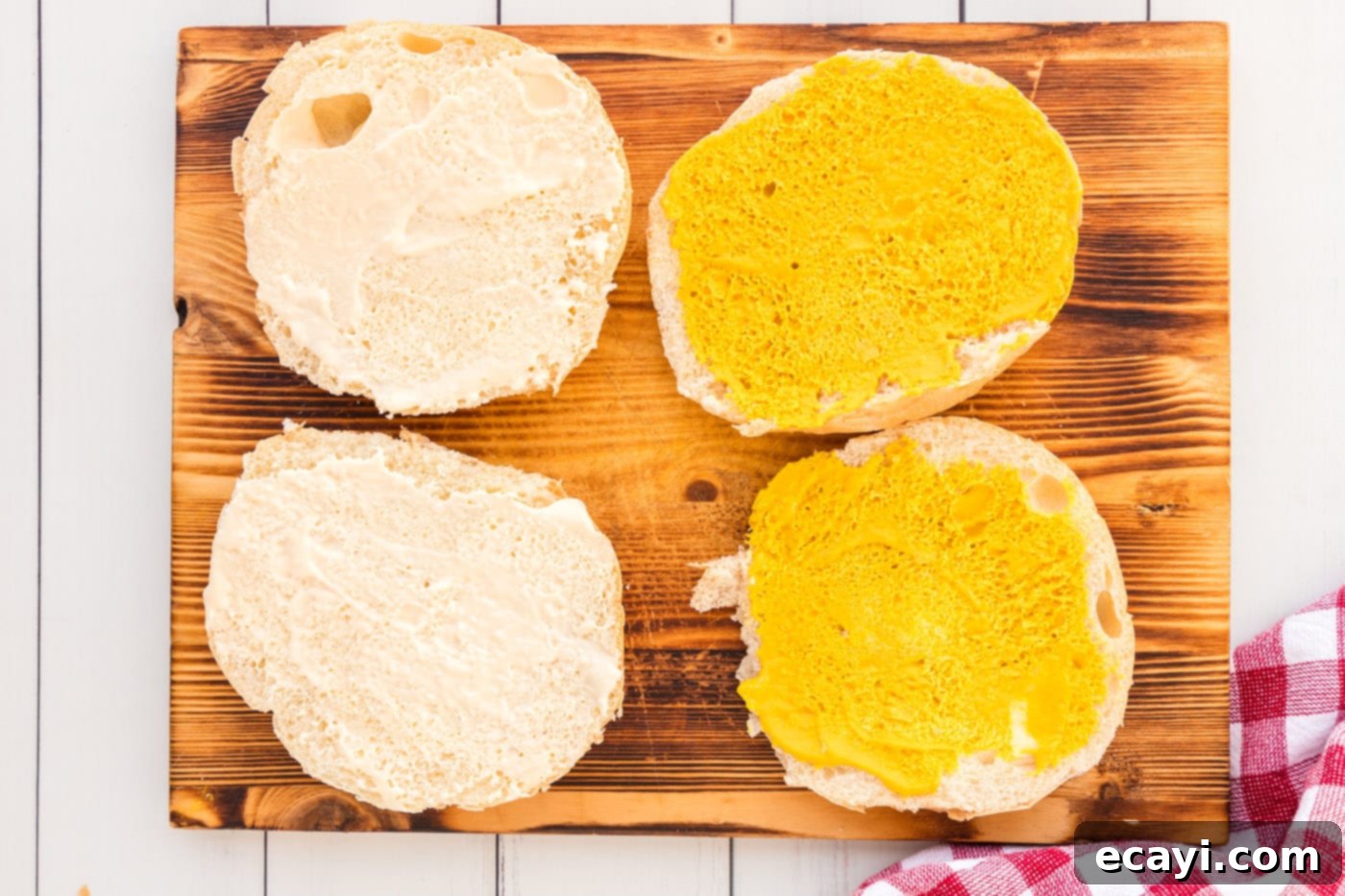 Tender Roast Beef Perfection 9 Spreading horseradish mayo and mustard onto a sandwich bun