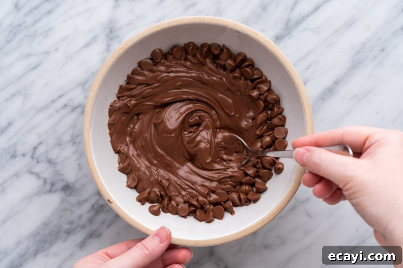 Decadent Chocolate Peanut Butter Hearts 12 stirring melted chocolate chips in a bowl