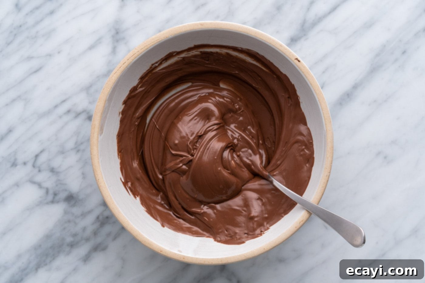 Decadent Chocolate Peanut Butter Hearts 13 melted chocolate in a bowl with a spoon