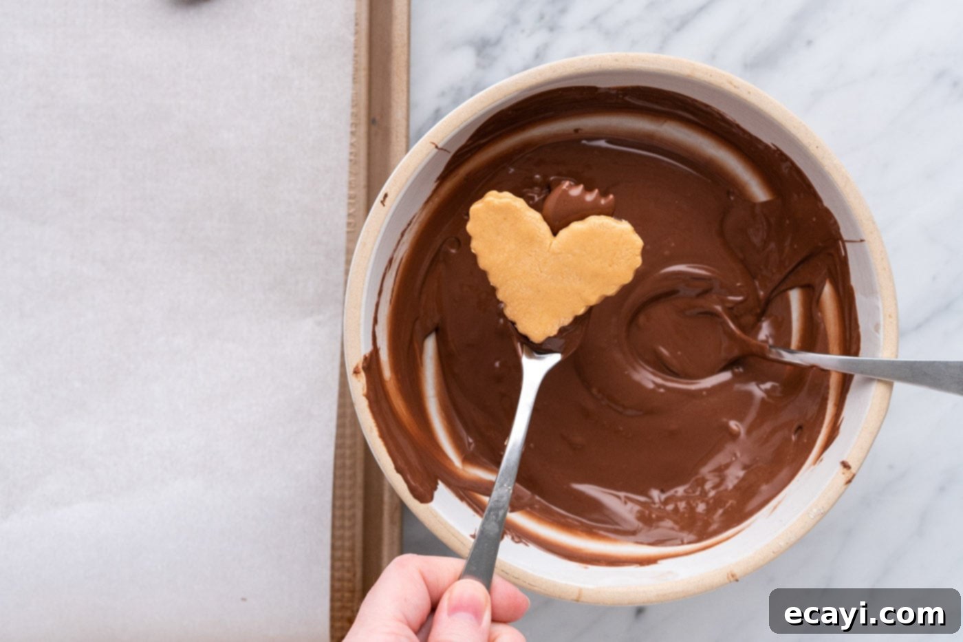 Decadent Chocolate Peanut Butter Hearts 14 dipping peanut butter heart into melted chocolate with a fork