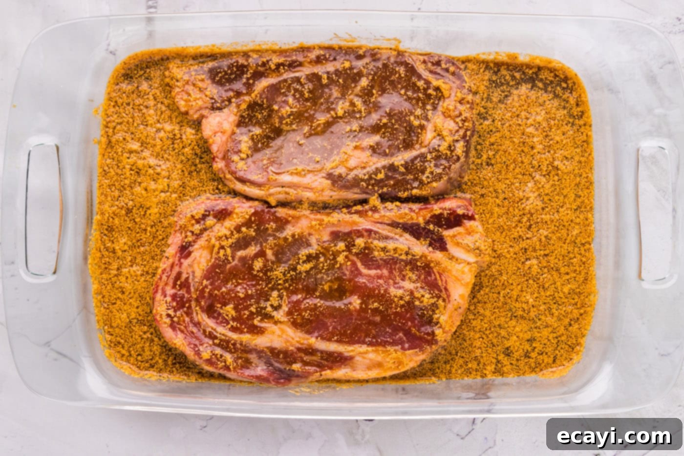 The Perfect Ribeye Marinade 9 ribeye steak soaking in marinade mixture in a glass container