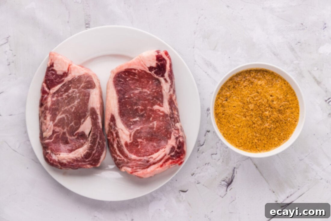 The Ultimate Cast Iron Ribeye 4 Selection of fresh ingredients for Cast Iron Ribeye, including raw steaks, olive oil, and herbs
