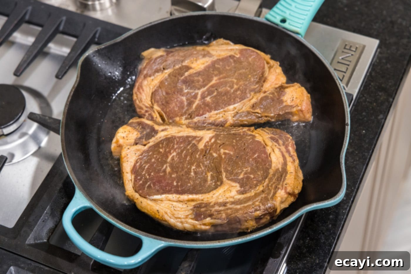 The Ultimate Cast Iron Ribeye 6 Marinated ribeye steaks sizzling in a cast iron skillet