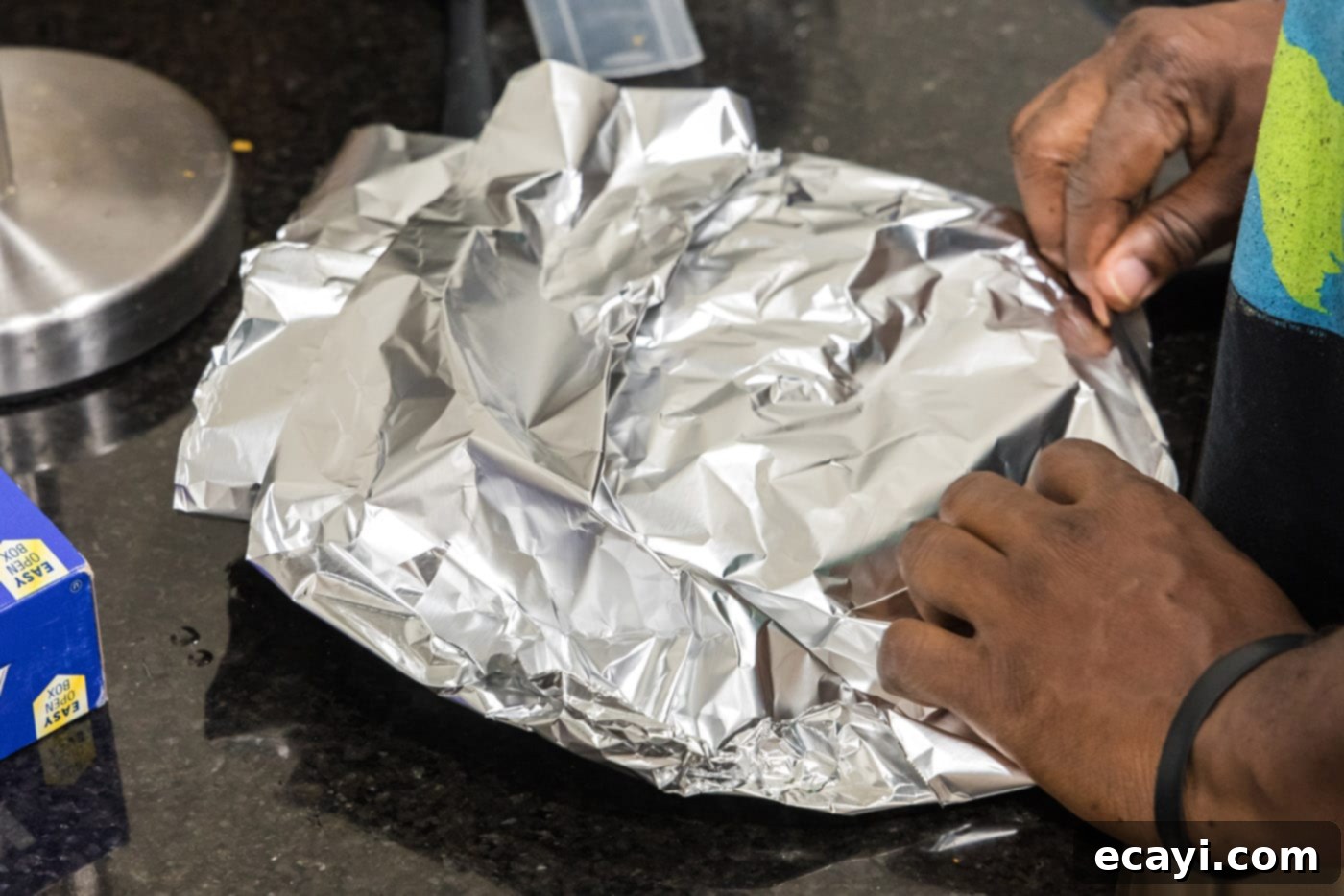 The Ultimate Cast Iron Ribeye 9 Hands folding foil over cooked ribeye steaks for resting