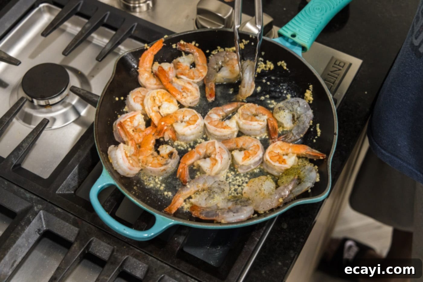 Sizzling Garlic Butter Shrimp 12 Tongs flipping shrimp over in a skillet to ensure even cooking and coating