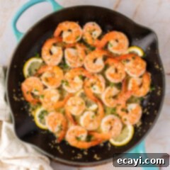 Sizzling Garlic Butter Shrimp 15 Overhead photo of Garlic Butter Shrimp in a skillet with lemon wedges and fresh parsley