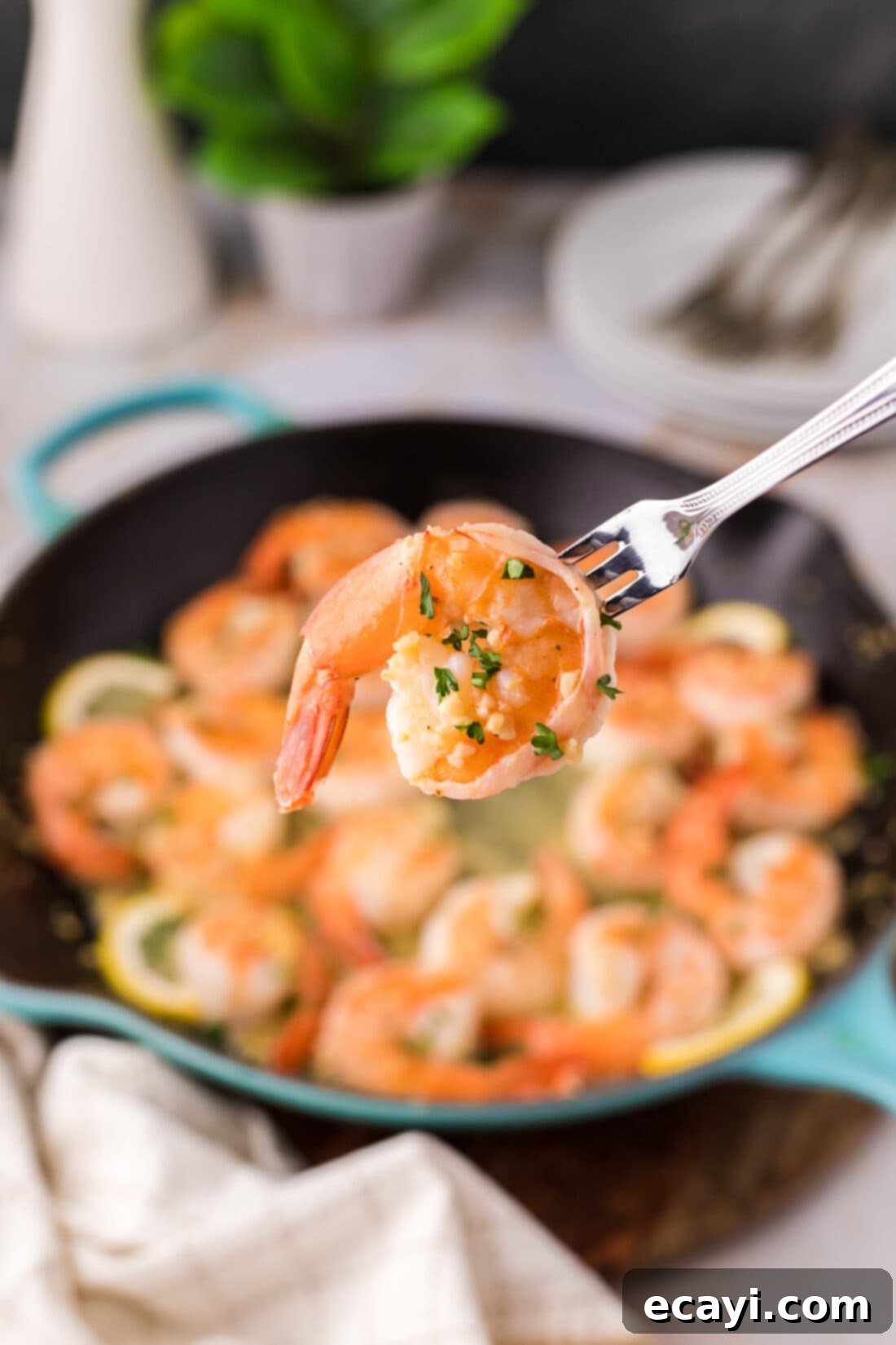 Sizzling Garlic Butter Shrimp 3 A single piece of perfectly cooked Garlic Butter Shrimp on a seafood fork, showing the rich butter sauce and seasoning