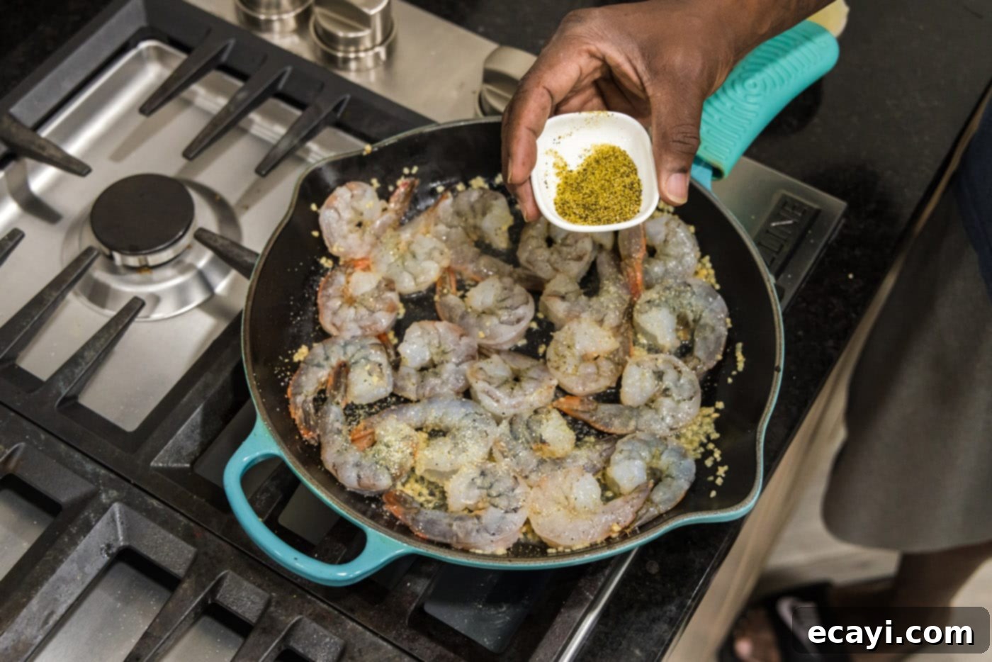 Sizzling Garlic Butter Shrimp 10 Adding lemon pepper to shrimp cooking in a skillet