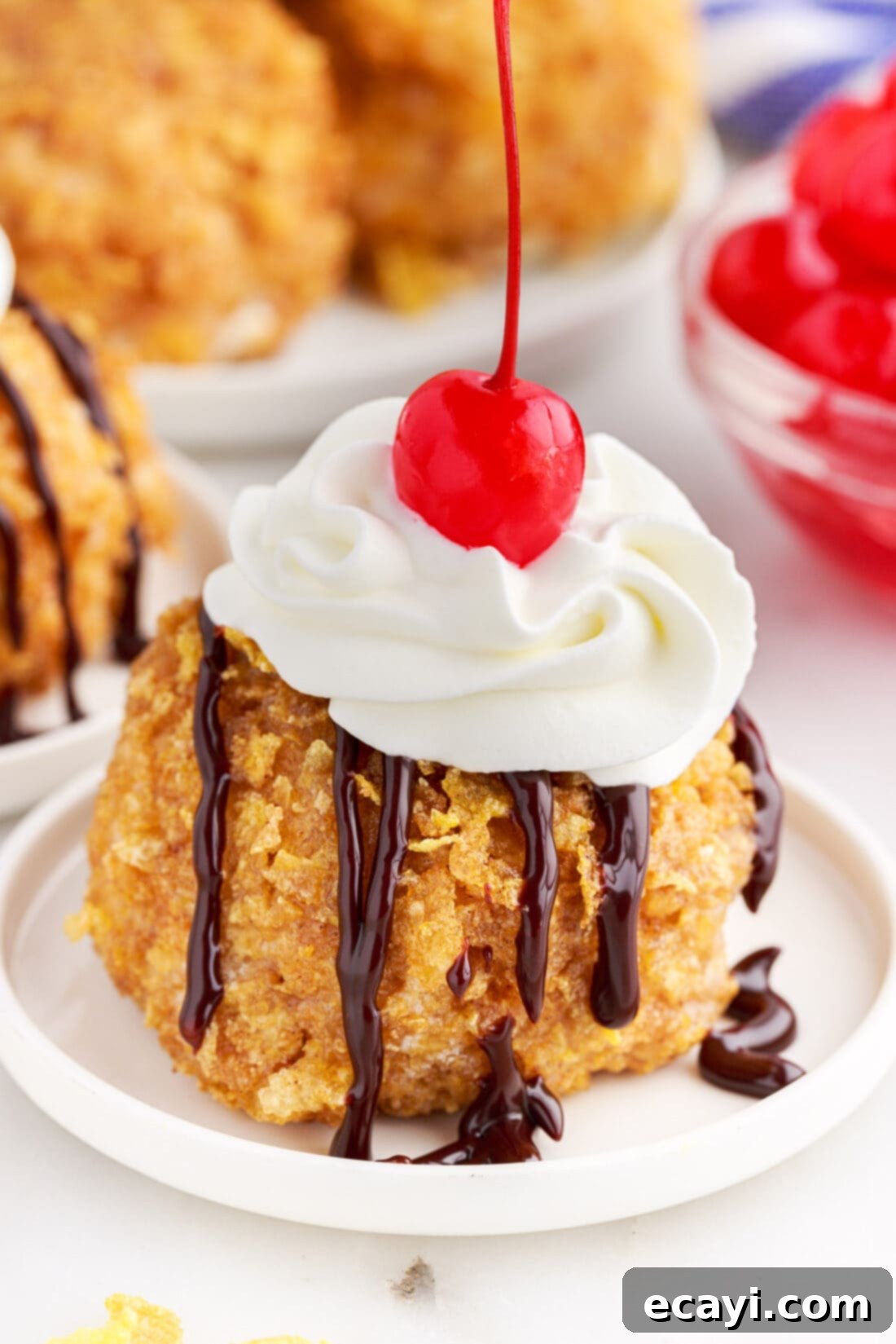 Crispy-Coated Cream Dream 3 Fried Ice Cream on a plate with whipped cream and a cherry on top