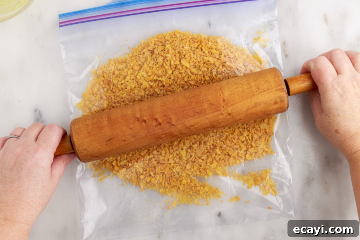 Crispy-Coated Cream Dream 9 crushed cornflakes in a bag with rolling pin