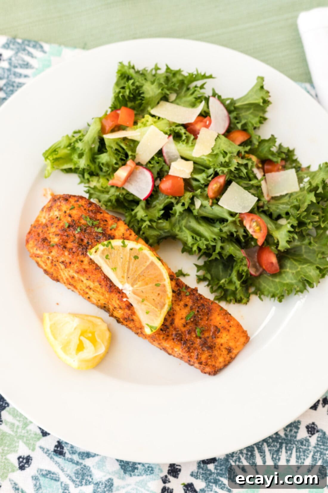 Easy Crispy Air Fryer Salmon 2 Air Fryer Salmon on a plate with a side salad, garnished with lemon