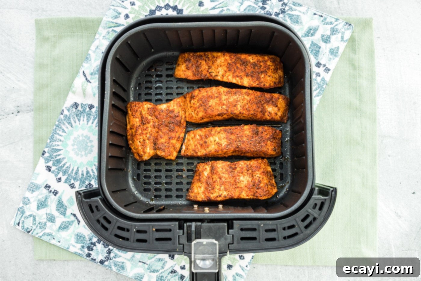 Easy Crispy Air Fryer Salmon 8 A perfectly cooked piece of salmon being removed from the air fryer with a fish turner