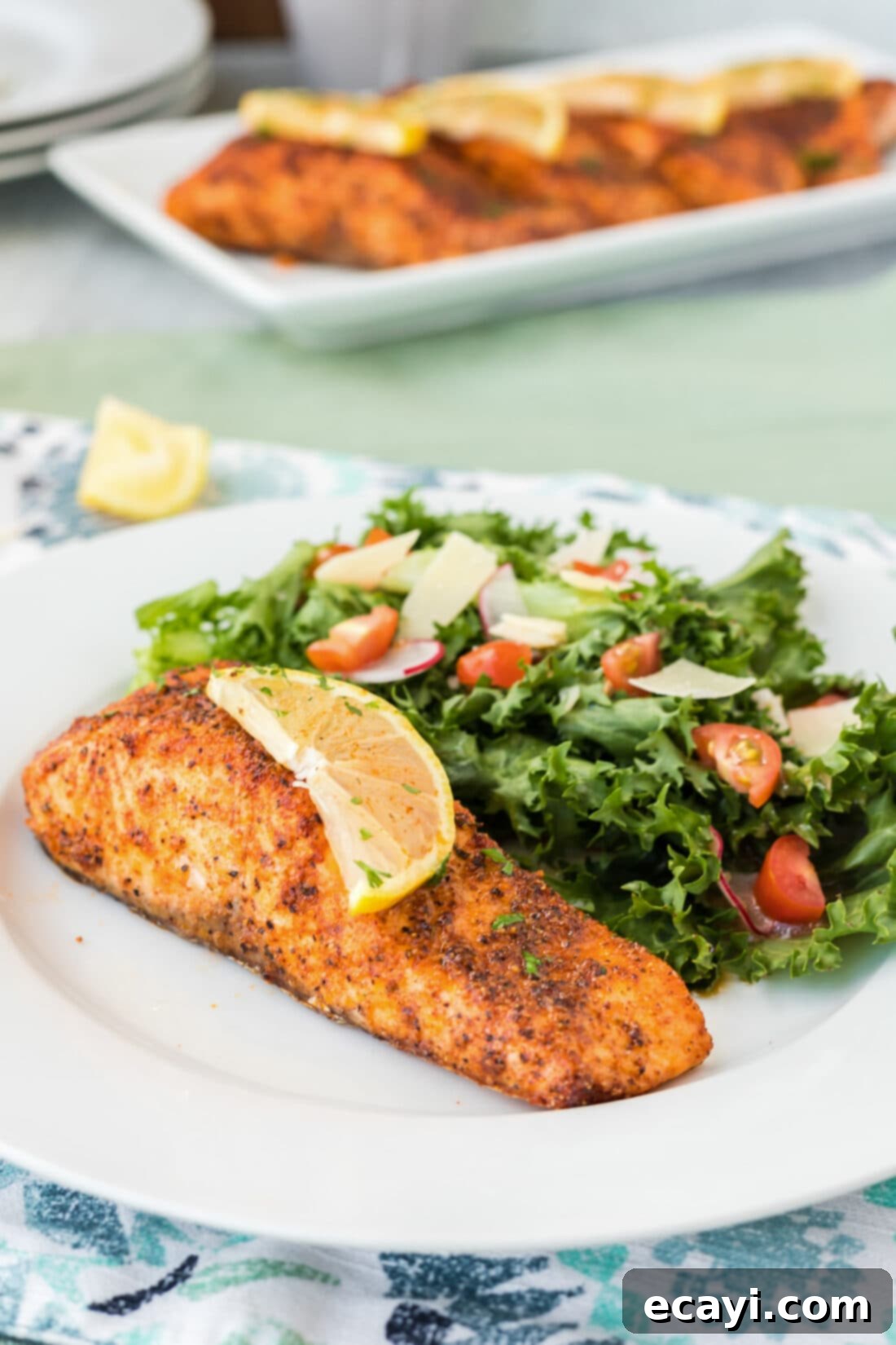 Easy Crispy Air Fryer Salmon 9 Air Fryer Salmon on a plate with a slice of lemon on top, ready to serve