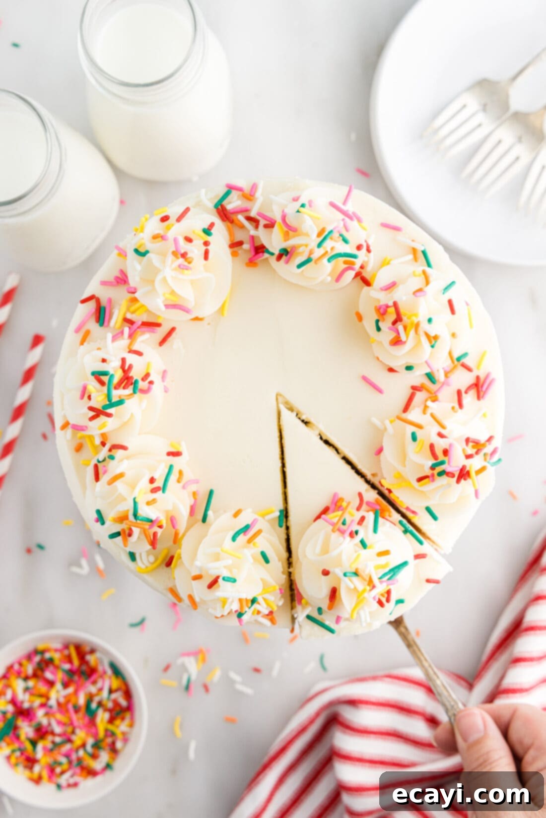 Classic Funfetti Cake 2 Overhead photo of Funfetti Cake with a slice being removed