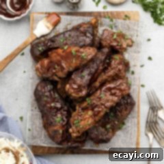 Fall-Off-The-Bone Slow Cooker BBQ Country Ribs 12 Slow Cooker Barbecued Country Style Ribs resting on a parchment lined wooden platter