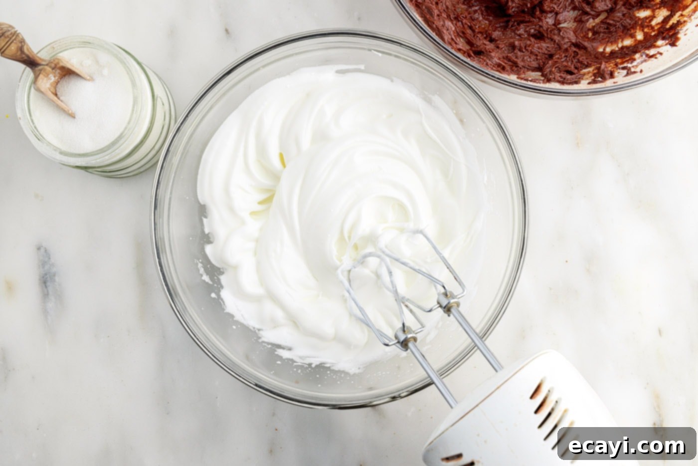 Molten Chocolate Bliss 8 whipped egg whites in a mixing bowl using a hand mixer