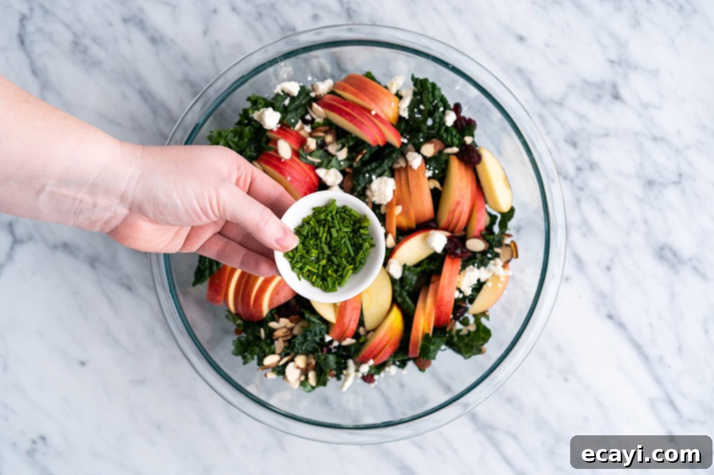 Signature Kale Salad 11 adding chives to kale salad in a bowl