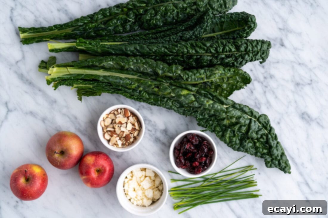 Signature Kale Salad 4 Selection of fresh ingredients for kale salad including kale, apples, craisins, almonds, feta, and chives.