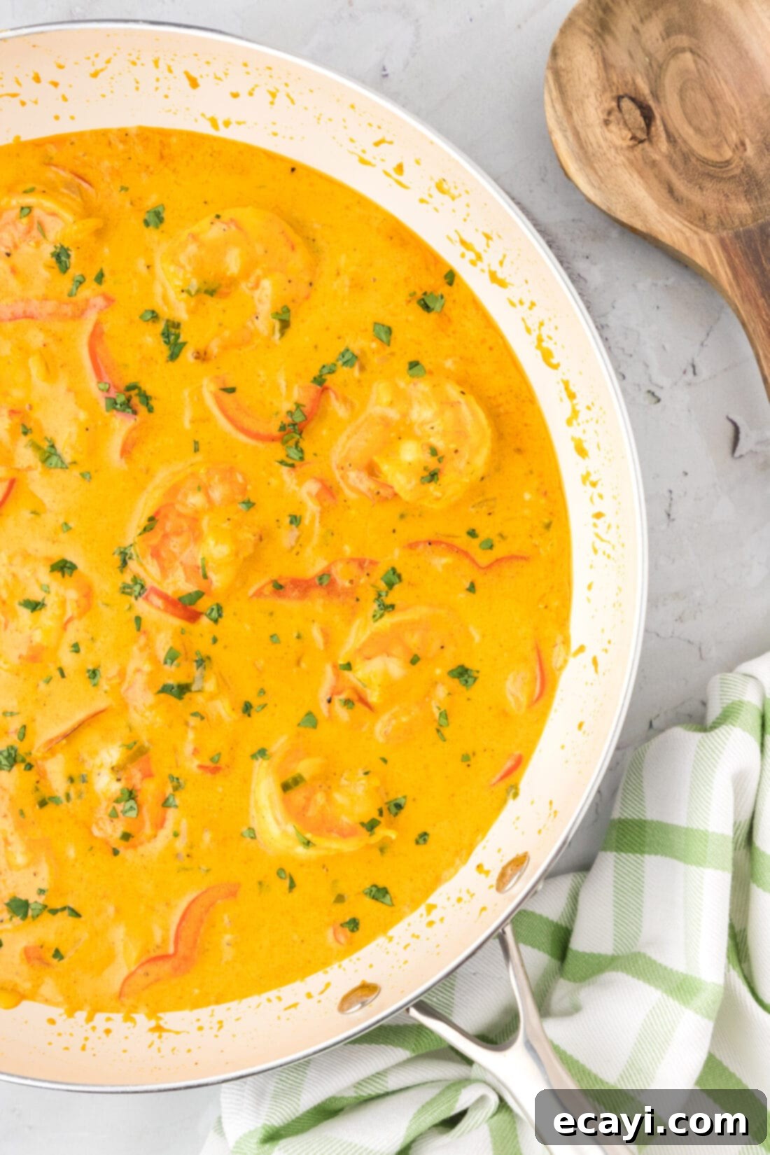 Mouthwatering Shrimp Curry 3 Close-up view of the simmering creamy shrimp curry in a large skillet, highlighting the vibrant colors of the shrimp, bell peppers, and onions within the rich gravy.