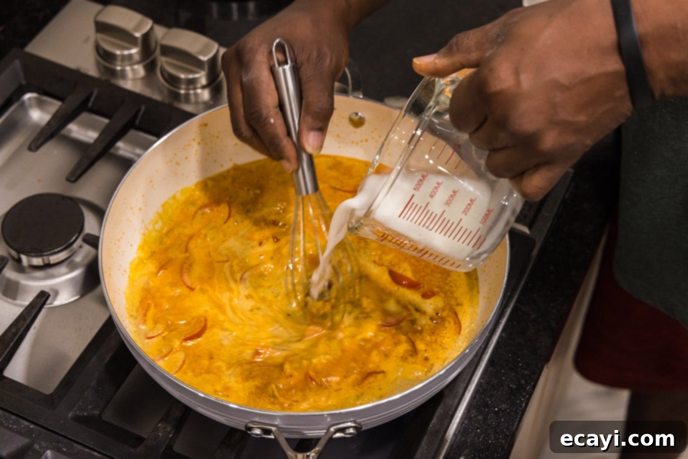 Mouthwatering Shrimp Curry 9 A cornstarch and water slurry being poured into the simmering curry, visibly thickening the sauce as it's whisked in.