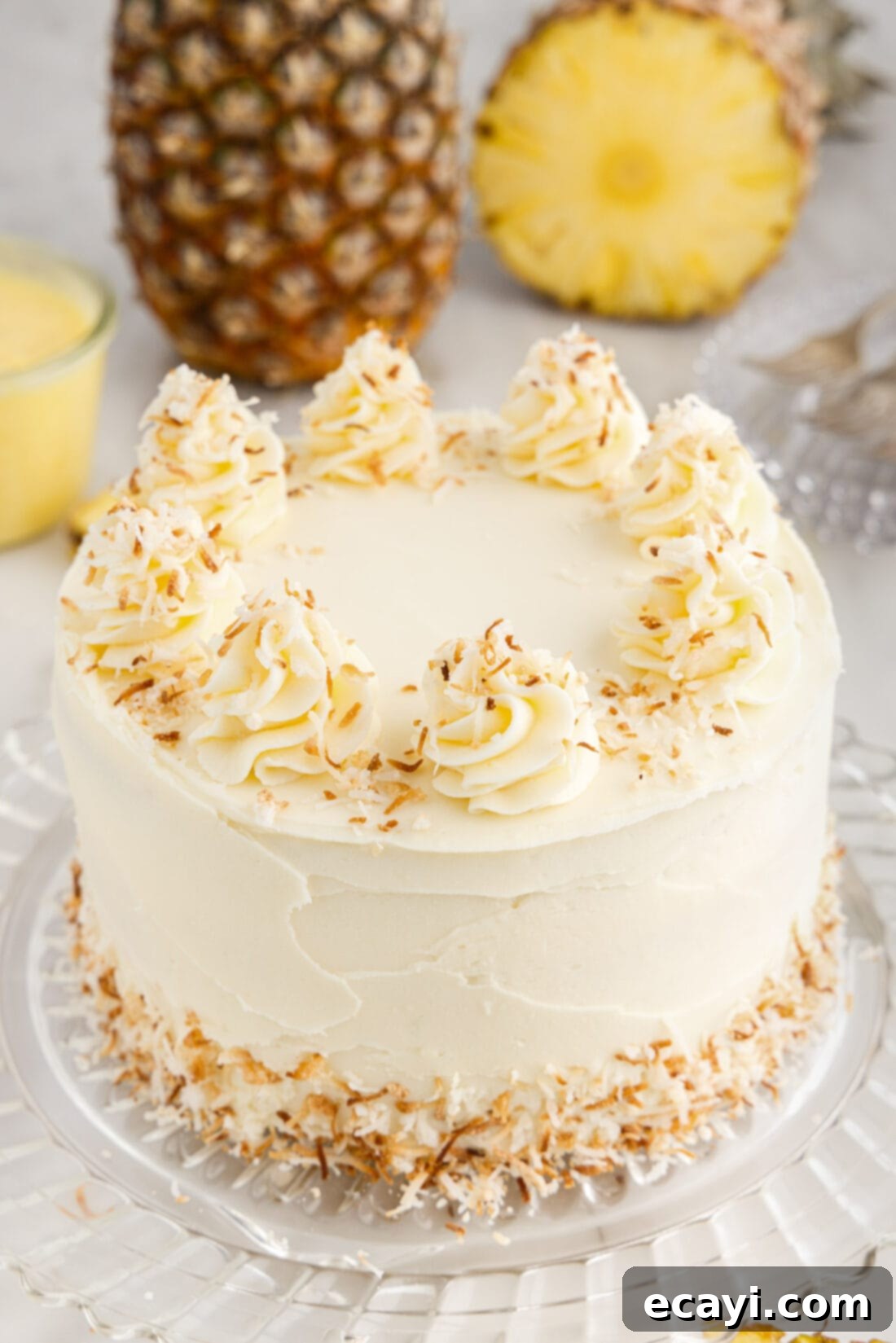 Pineapple Coconut Paradise 2 Pineapple Coconut Cake on a cake stand, beautifully layered and frosted