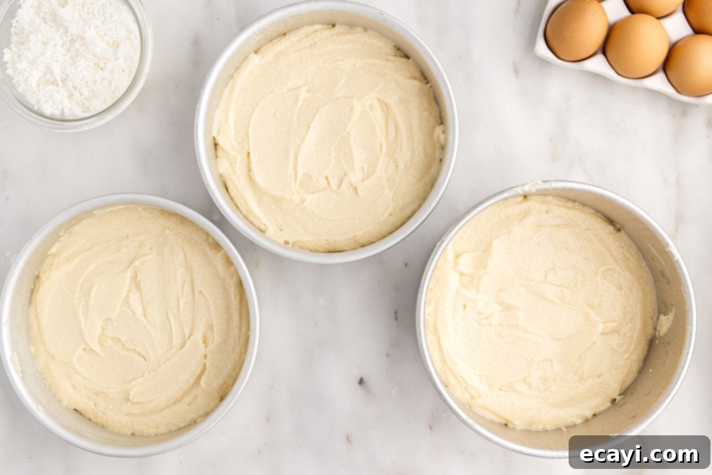 Pineapple Coconut Paradise 11 coconut cake batter in three round cake pans, ready for baking