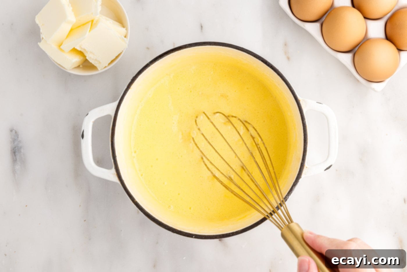 Pineapple Coconut Paradise 14 whisking pineapple curd in a saucepan over medium-low heat