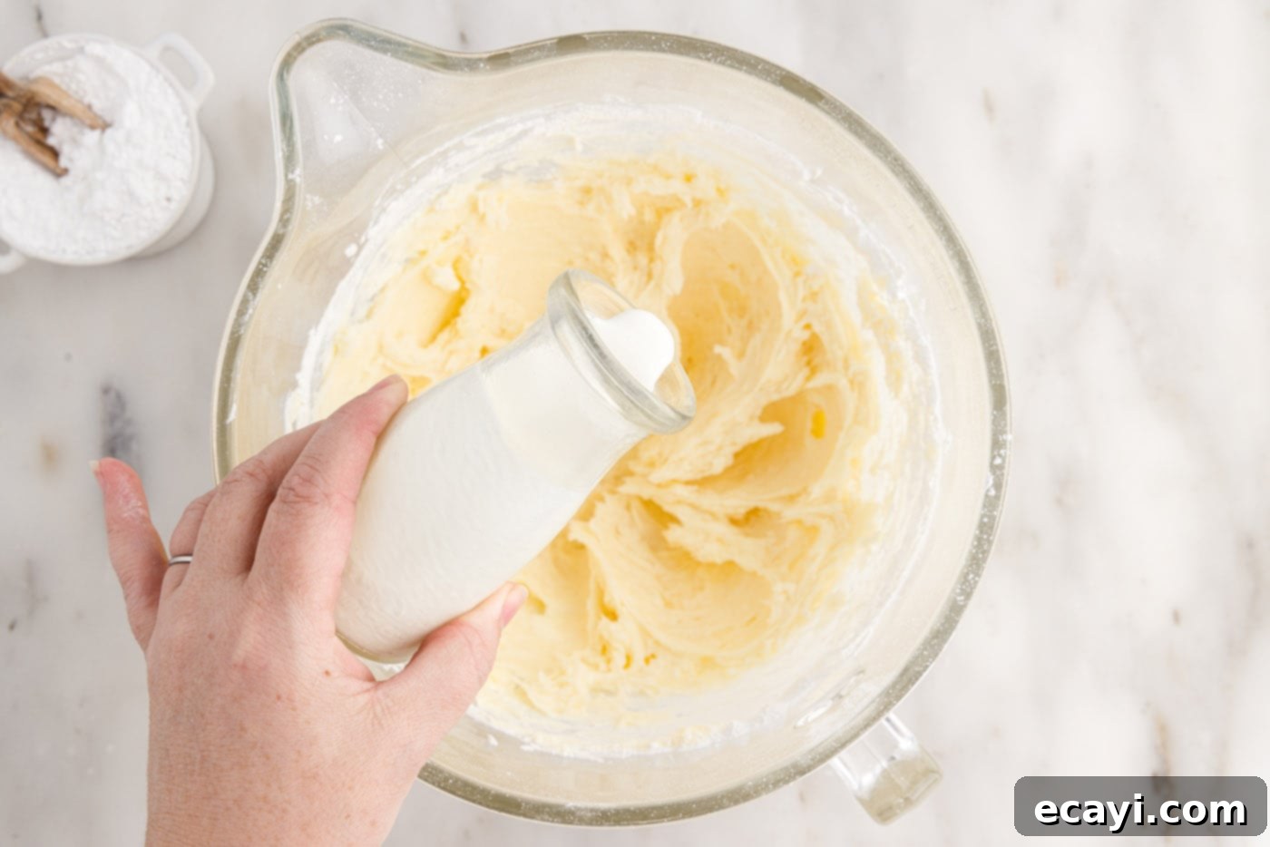 Pineapple Coconut Paradise 19 pouring heavy cream into cream cheese frosting mixture to adjust consistency