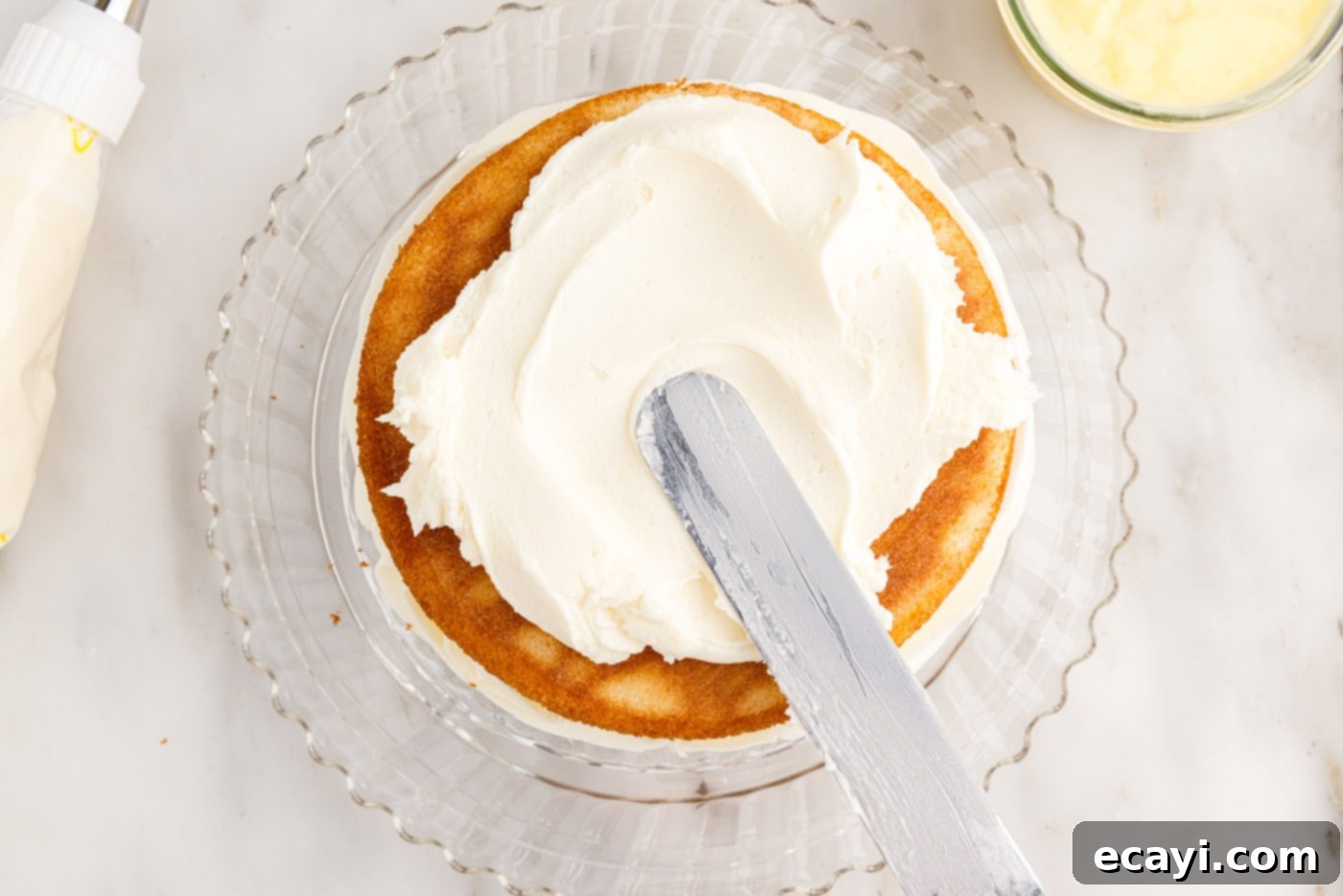 Pineapple Coconut Paradise 22 spreading frosting smoothly on the sides of the layered cake