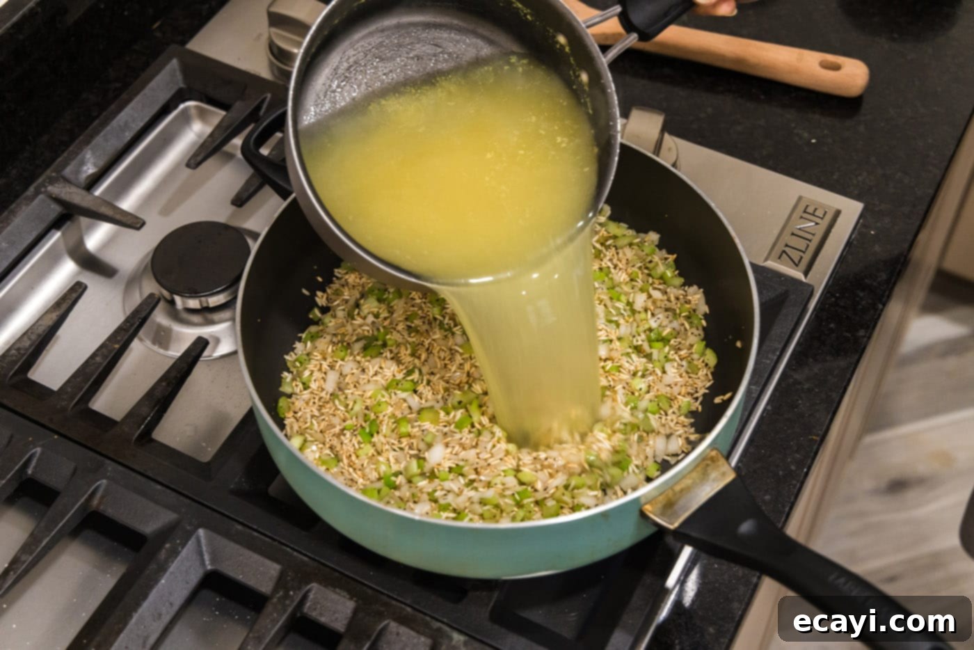 Savory Pilaf Perfection 9 pouring chicken stock and water into rice pilaf in a skillet