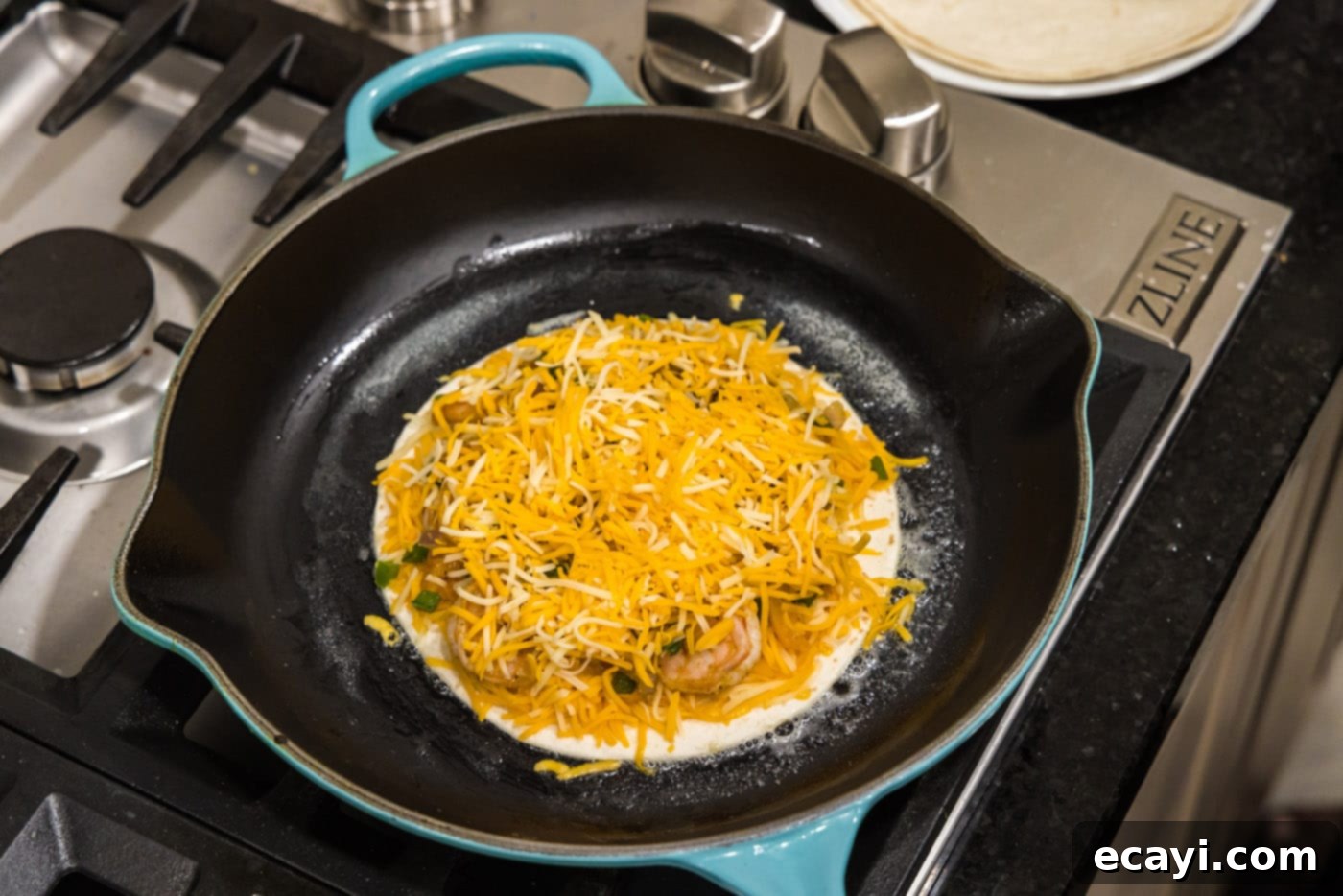 Zesty Shrimp Quesadilla 11 Sprinkling shredded Colby Jack cheese over the shrimp and vegetable filling on a tortilla.