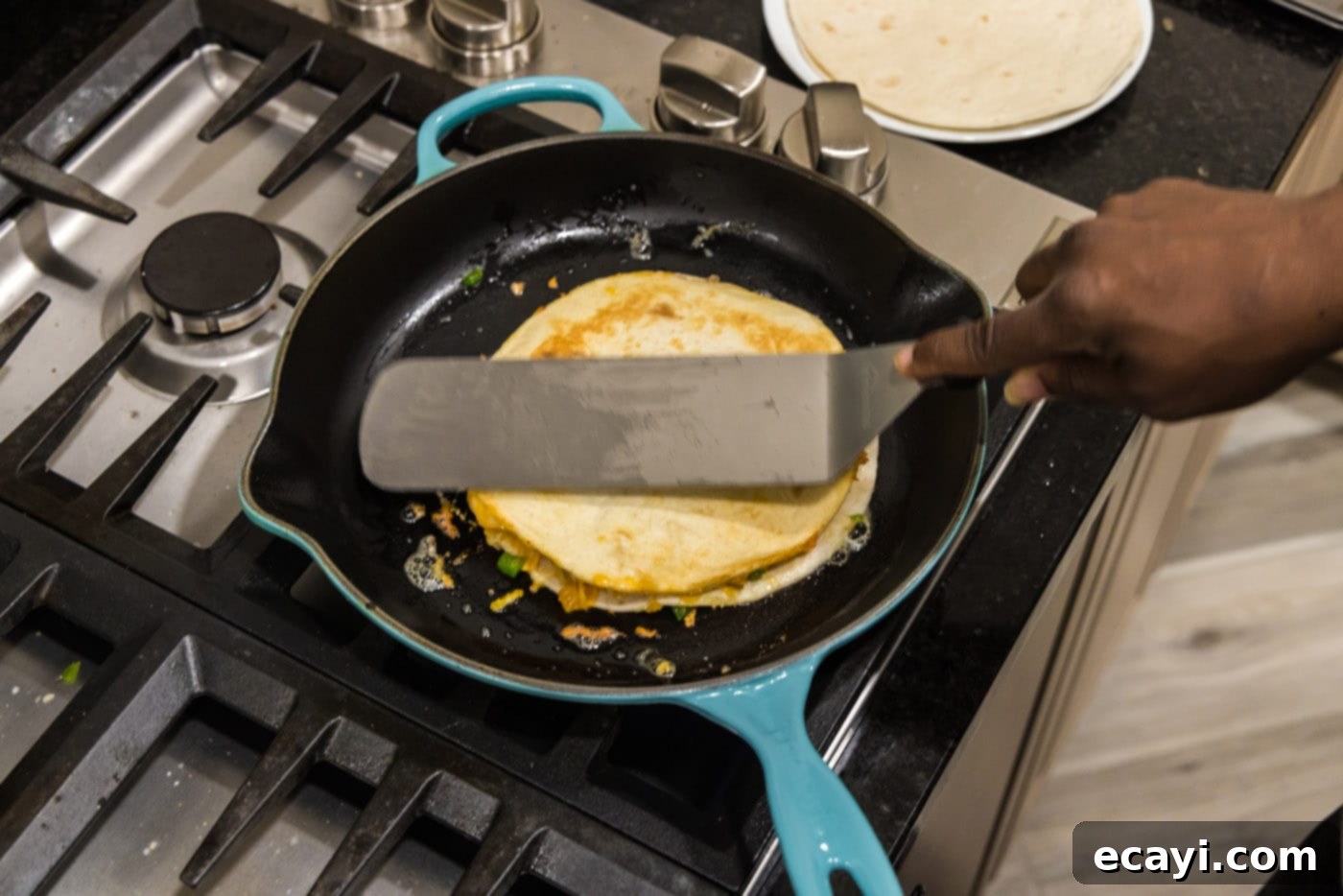 Zesty Shrimp Quesadilla 14 Using a spatula to gently press down on the quesadilla in a skillet, ensuring even browning and melting.