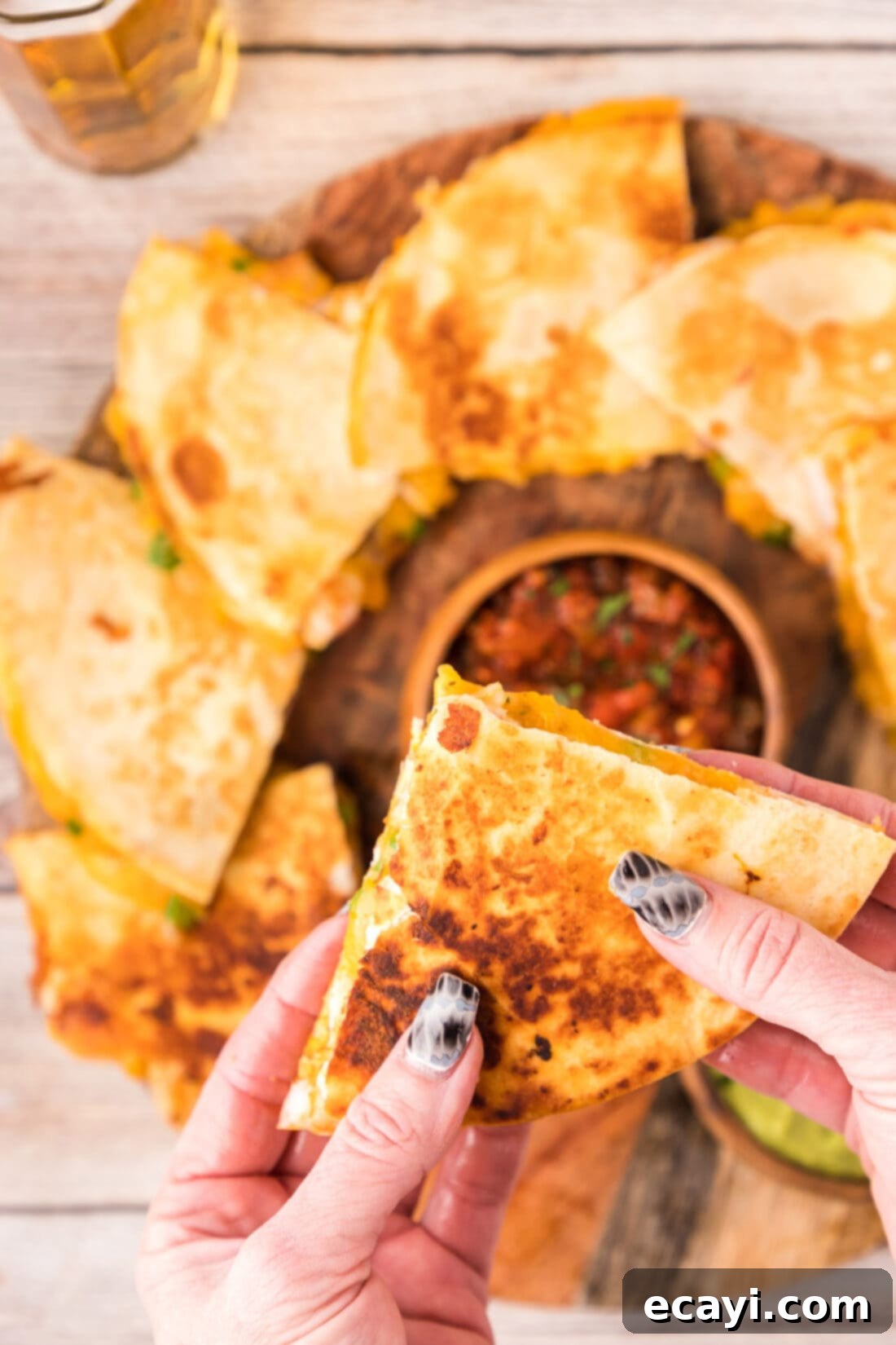 Zesty Shrimp Quesadilla 16 A hand holding a perfectly triangular-cut Shrimp Quesadilla, showcasing the rich filling.