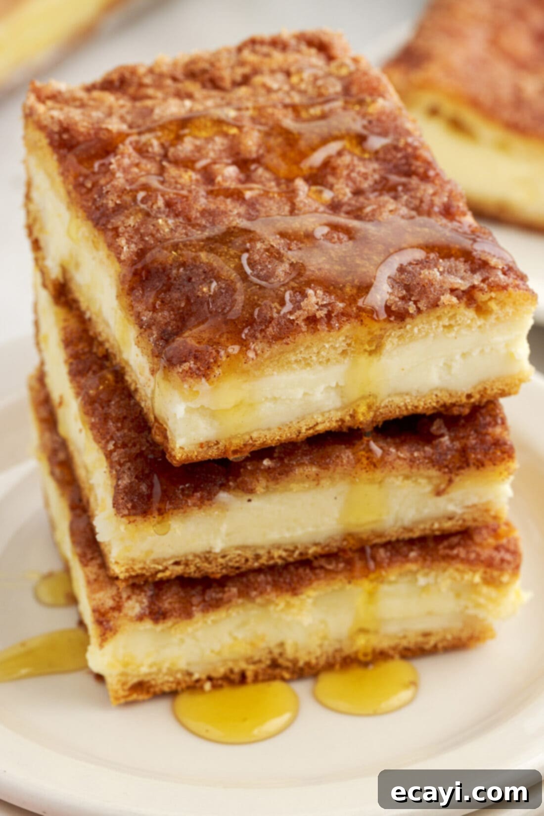 Cinnamon Swirl Sopapilla Cheesecake 17 A beautiful stack of three neatly cut Sopapilla Cheesecake squares, showcasing their inviting golden layers and creamy interior, ready to be enjoyed.