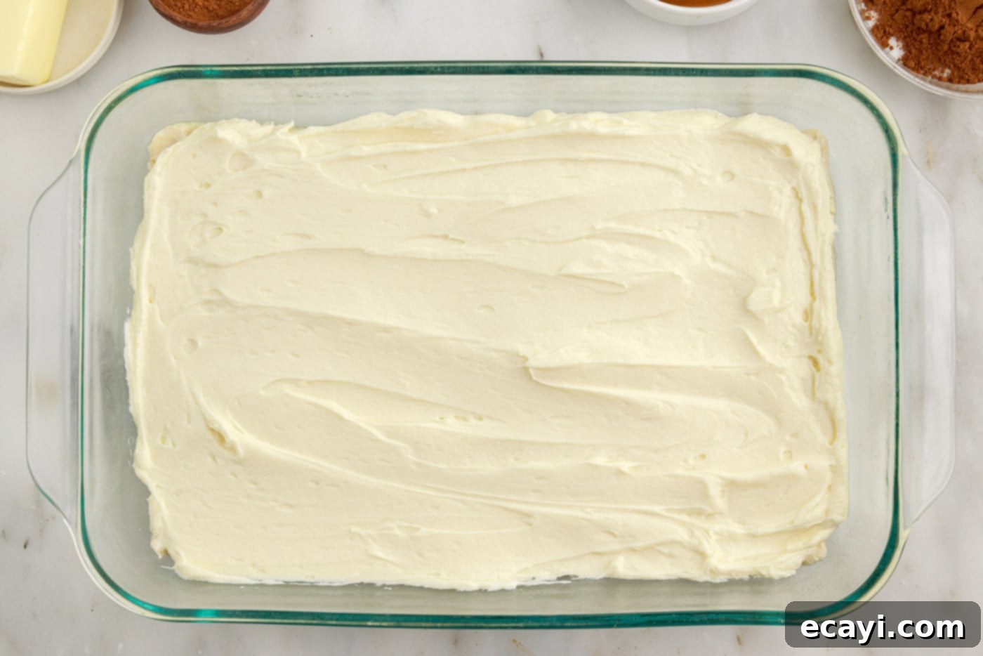 Cinnamon Swirl Sopapilla Cheesecake 9 The smooth, white cheesecake layer fully covering the crescent roll base, creating a distinct and appealing middle section in the baking dish.