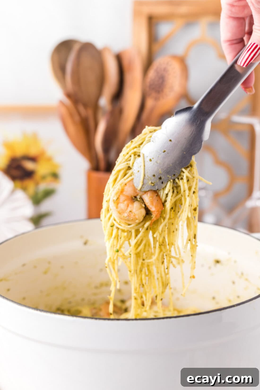 Vibrant Pesto Prawn Pasta 11 Tongs picking up Shrimp Pesto Pasta from a plate