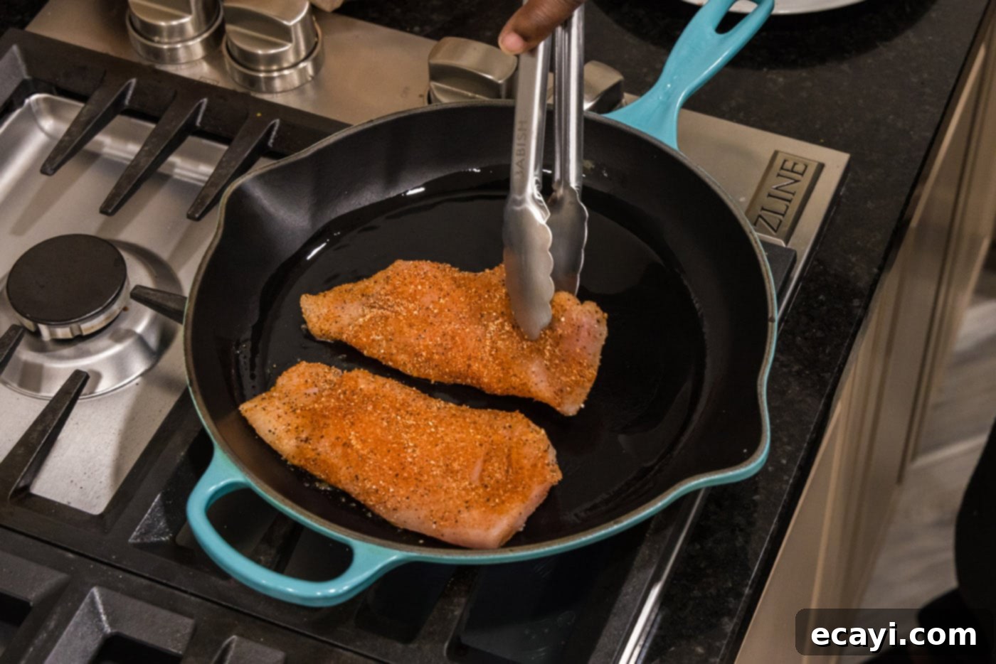 Cajun Spiced Blackened Chicken 8 Tongs gently placing seasoned chicken breasts into a sizzling hot skillet.