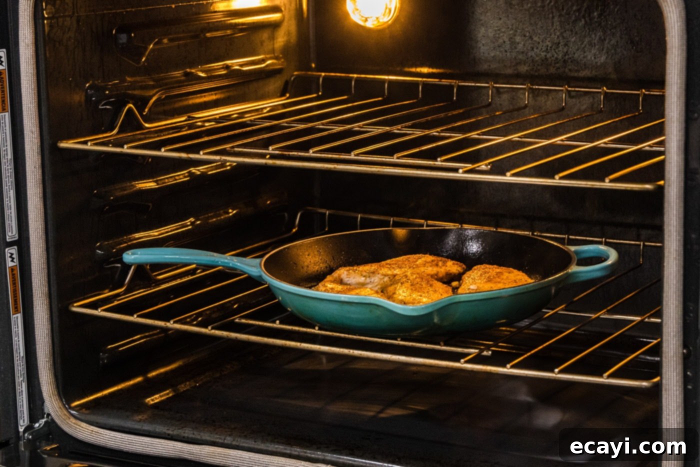Cajun Spiced Blackened Chicken 10 A cast iron skillet with seared chicken breasts being carefully transferred to a preheated oven.